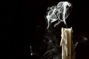 Photo of a candle being blown out.