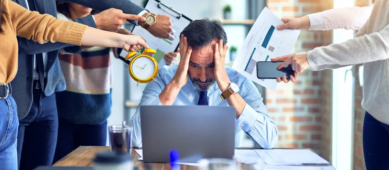 Photo of a burned-out man facing many demands for his attention.