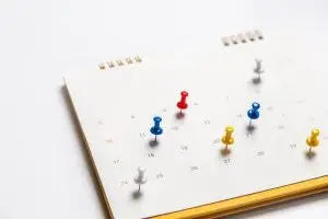Photo of a calendar with colored pins inserted into special days.