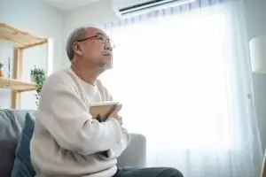 Photo of an older man clutching a picture frame to his chest.