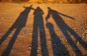 Image of people casting long shadows on the ground.
