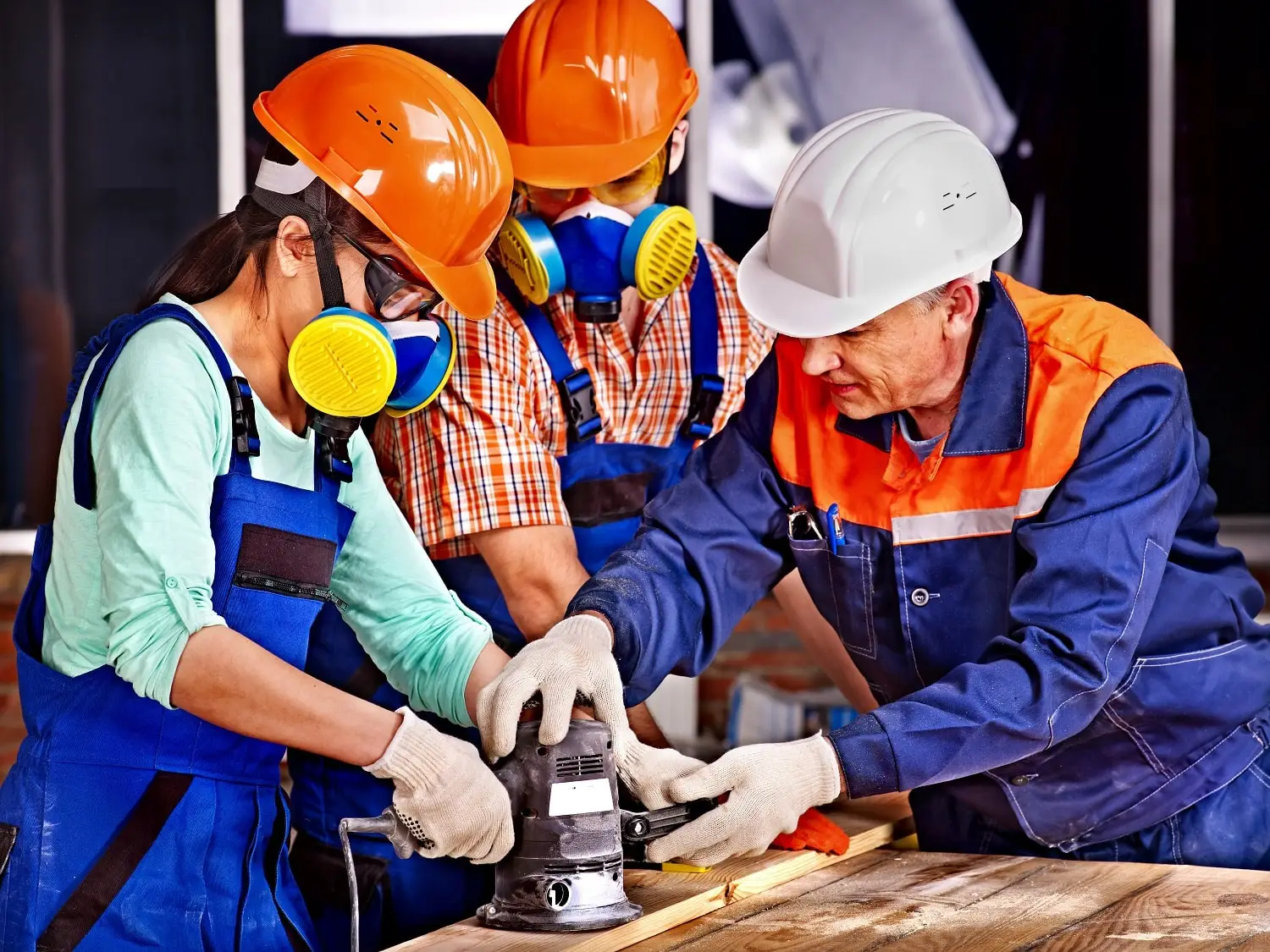 Photo of older construction worker mentoring younger employees.