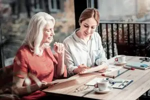 A baby boomer woman talks with a millennial woman.