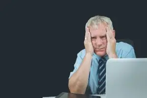 Photo of a bored and stressed older worker.
