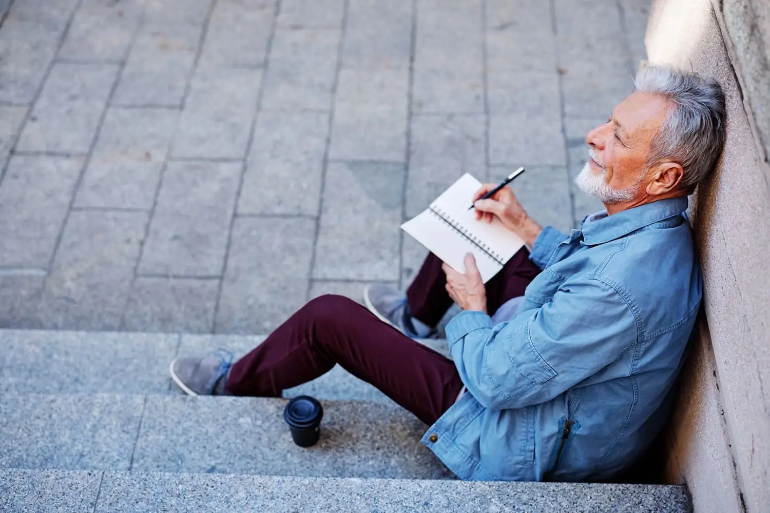Photo of a man creating a list outside.