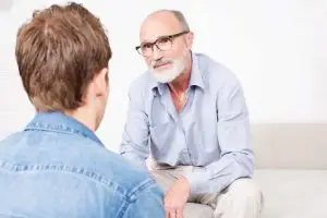 Photo of an older man sharing a story with a younger man.