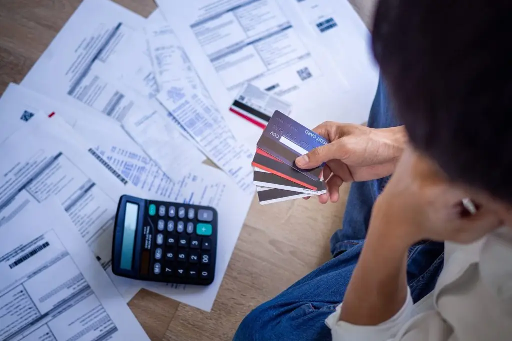 Photo of someone using credit cards to pay bills.
