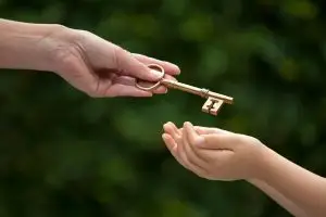 Photo of an adult handing over a key to a child