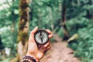 Photo of a person lost on a trail with a compass
