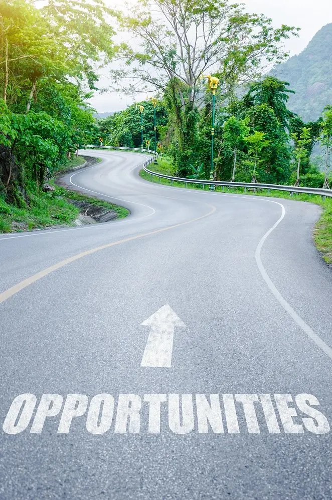 Sign painted on road pointing toward opportunities.